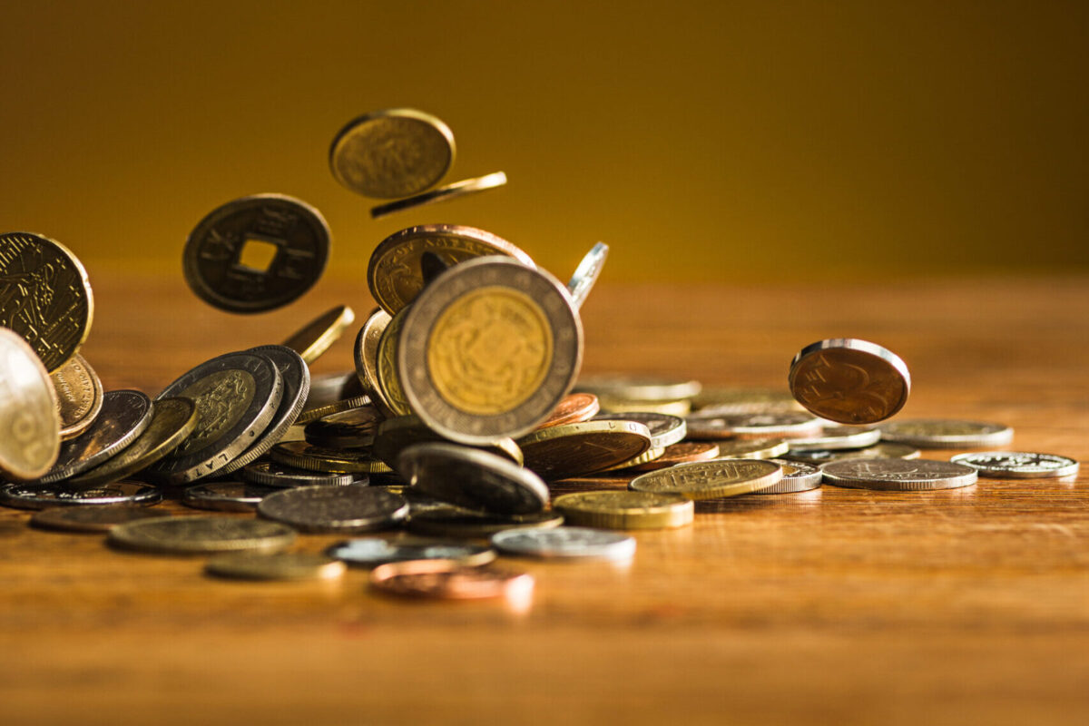 The silver and golden coins and falling coins on wooden table background